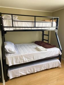 a bedroom with two bunk beds with white sheets at Refugio Nordico de 3 habitaciones inc Cochera en 2do piso in Trujillo +8 photos