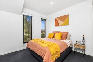 a bedroom with a bed with orange and yellow pillows at Bayview Luxe- Sleeping 14, Pet Friendly, Views- 4 bedroom, lounge with sofa beds in Curlewis