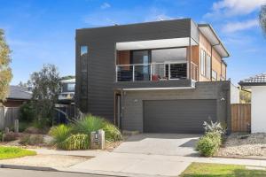 a large black house with a garage at Bayview Luxe- Sleeping 14, Pet Friendly, Views- 4 bedroom, lounge with sofa beds in Curlewis +4 photos