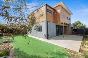 a house with a green lawn in front of it at Bayview Luxe- Sleeping 14, Pet Friendly, Views- 4 bedroom, lounge with sofa beds in Curlewis