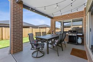 a patio with a table and chairs and a grill at City & Surf Getaway in Grovedale