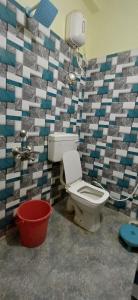 a bathroom with a toilet and a tile wall at Hotel relaxinn in Saharsa