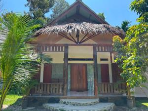 a small house with a thatched roof at Leuser Inn & Jungle Trekking in Bukit Lawang