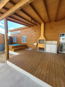 a large room with a wooden deck at Casa Dunas - Las Caracolas - Cassino RS in Rio Grande