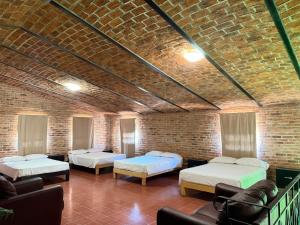 a room with two beds and a brick wall at Ribera del Lago in Jocotepec