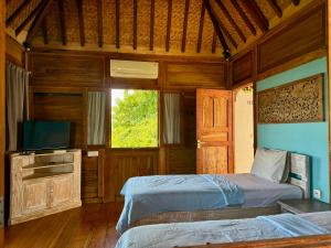a bedroom with two beds and a television in it at Villa Bakso Mentigi in Teluknarat +24 photos