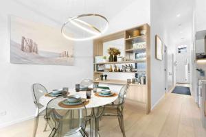 a kitchen and dining room with a table and chairs at Mod House Ocean Grove- Walk to the shops, cafes, beach and park! Brand new luxury apartment in gated complex in Ocean Grove
