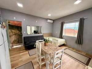 a kitchen and living room with a table and a couch at Kit Net in Governador Celso Ramos +2 photos