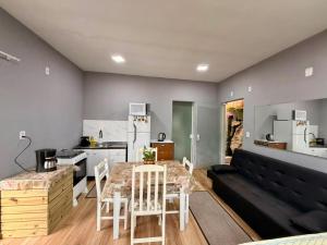 a kitchen and living room with a table and a couch at Kit Net in Governador Celso Ramos