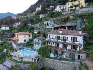 a group of houses on a hill with a swimming pool at Wonderful flat with swimming pool, lift and garden in Gravedona +33 photos