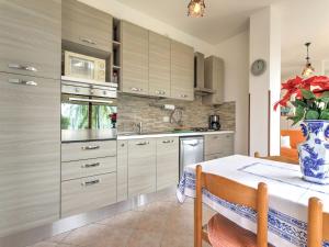 a kitchen with a table with a vase on it at Wonderful flat with swimming pool, lift and garden in Gravedona
