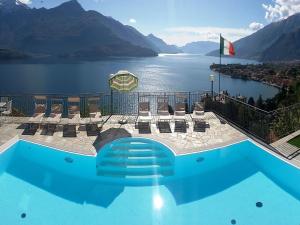 a pool with chairs and a view of a lake at Wonderful flat with swimming pool, lift and garden in Gravedona