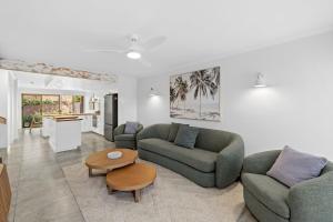a living room with two couches and a table at Beach Street - Town Location - Stone Real Estate Yamba in Yamba