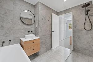 a bathroom with a sink and a mirror at Beach Street - Town Location - Stone Real Estate Yamba in Yamba +15 photos