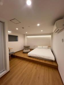 a bedroom with a white bed and a desk at Leisure Hotel II 東中野 in Tokyo
