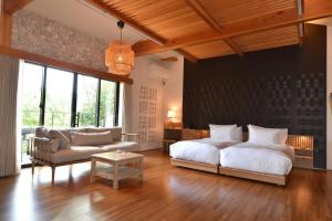 a bedroom with a bed and a couch and a table at Kohanyu in Kami +86 photos