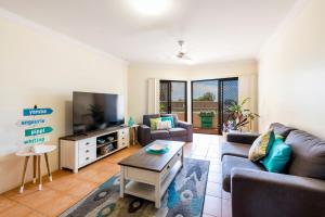 a living room with a couch and a tv at Breakers 1-3 - Ocean Views - Stone Real Estate Yamba in Yamba