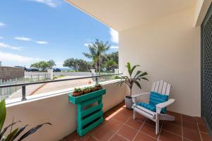 a balcony with a blue chair and a plant at Breakers 1-3 - Ocean Views - Stone Real Estate Yamba in Yamba