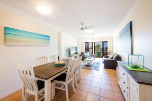 a dining room and living room with a table and chairs at Breakers 1-3 - Ocean Views - Stone Real Estate Yamba in Yamba