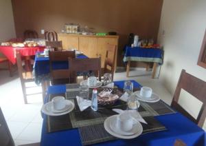 a dining table with a blue table cloth on it at Pousada Flores in Itaúnas