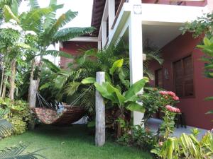 uma casa com um monte de plantas à frente dela em Pousada Flores em Itaúnas