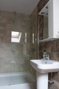 a bathroom with a sink and a shower at Casa Róza Vendégház in Sfântu-Gheorghe