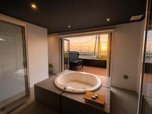 a large bath tub in a bathroom with a view at Coco Resort Futtsu in Futtsu