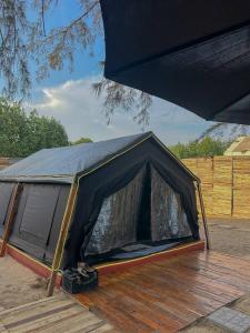 a black tent sitting on top of a wooden deck at Coody Seastar in Ban U Taphao