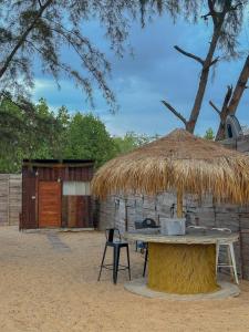a hut with a table and a chair in front of it at Coody Seastar in Ban U Taphao