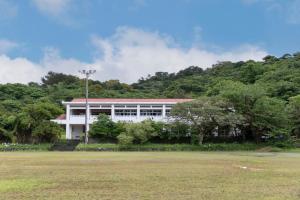 a white building with trees in front of a field at Bunagaya in Ujimi +19 photos
