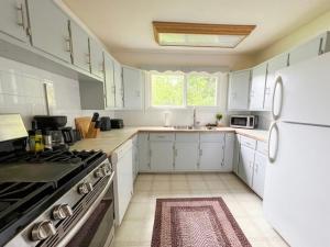 eine Küche mit weißen Schränken und einem weißen Kühlschrank in der Unterkunft Badlands Basecamp in Drumheller