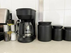 Eine Kaffeemaschine steht auf einer Theke neben Behältern. in der Unterkunft Badlands Basecamp in Drumheller + 7 Fotos