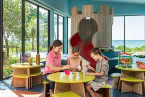 a woman and two children sitting at tables in a play room at Khao Lak Marriott Beach Resort & Spa in Khao Lak +134 photos