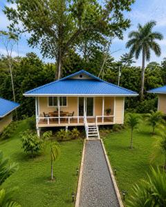 a small yellow house with a blue roof at Spot on Drago in Bocas Town