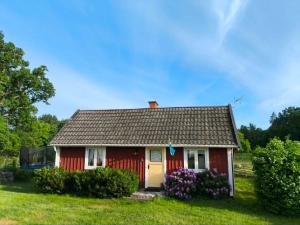 a red house with flowers in the yard at Sommargyllen Torp Brändabo Småland Kalmar Öland in Torsås