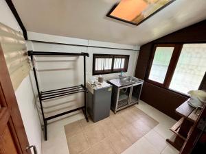 a small kitchen with a sink and a refrigerator at บ้านสวนบรรจงอักษร Bansuan Banjong Akkson in Rayong