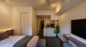 a hotel room with a bed and a television at Grand Residence Hotel Hakata Premier in Fukuoka