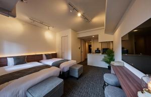 a hotel room with two beds and a kitchen at Grand Residence Hotel Hakata Premier in Fukuoka