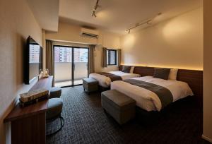 a hotel room with two beds and a window at Grand Residence Hotel Hakata Premier in Fukuoka