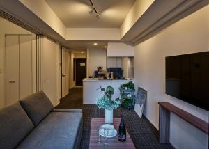 a living room with a couch and a table at Grand Residence Hotel Hakata Premier in Fukuoka