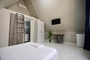 a bedroom with a bed and a table in a room at VLD House A Frame in Vadu