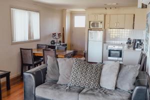 a living room with a couch and a kitchen at Seaspray 8 - Ocean Views - Stone Real Estate Yamba in Yamba