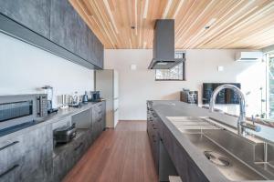 eine Küche mit Edelstahlgeräten und einer Holzdecke in der Unterkunft Noah Rusutsu in Rusutsu