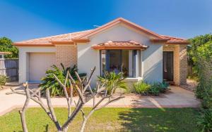 a house with a landscaping in front of it at Oceania Cottage- Pet Friendly -Stone Real Estate Yamba in Yamba
