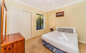 a bedroom with a bed and a dresser and a window at Oceania Cottage- Pet Friendly -Stone Real Estate Yamba in Yamba
