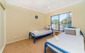 a room with two beds and a window at Oceania Cottage- Pet Friendly -Stone Real Estate Yamba in Yamba