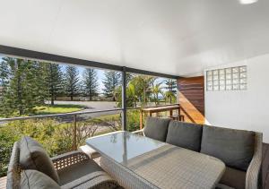 a living room with a couch and a glass table at Pippi Sands - Pet Friendly - Stone Real Estate in Yamba