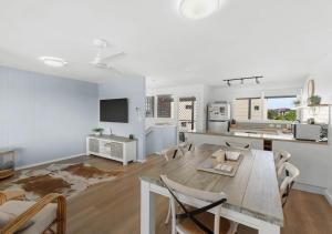 a kitchen and living room with a table and chairs at Pippi Sands - Pet Friendly - Stone Real Estate in Yamba