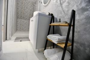 a bathroom with a sink and a shelf with towels at VLD House A Frame in Vadu +12 photos