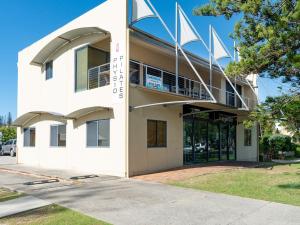 a white building with a balcony on the side of it at Six River - Town Location - Stone Real Estate Yamba in Yamba
